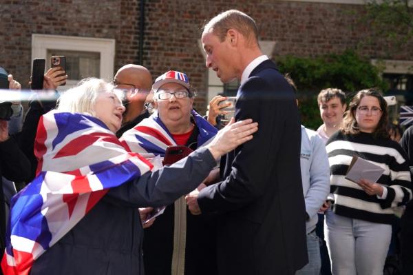 Prince William talking to women in flags. 