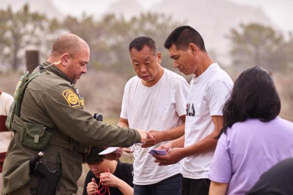 US Customs and Border Protection officers processed migrants after they crossed into the US from Mexico on Tuesday.