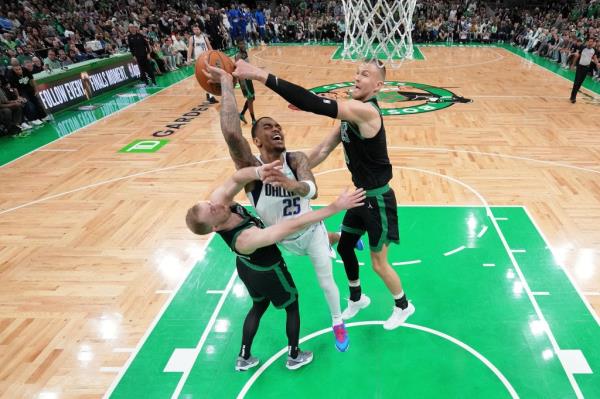 Boston Celtics forward Sam Hauser (left) and center Kristaps Porzingis (right) block the shot of Dallas Mavericks forward P.J. Washington (25) during the third quarter in game two of the 2024 NBA Finals at TD Garden. 