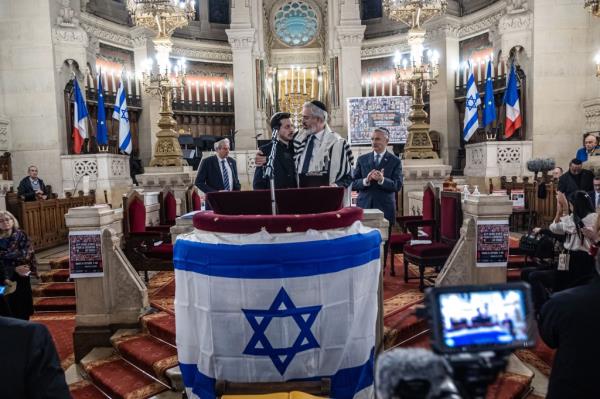 Moshe Sebbag (C-R), Chief Rabbi of the Grande Synagogue of Paris, greets Daniel Toledano (C-L), brother of hostage Elia Toledano as he participates in a vigil with relatives of Israeli hostages held since the 07 October attacks by Hamas