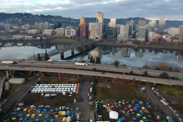  In this aerial photo, tents housing people experiencing homelessness are set up on a vacant parking lot in Portland, Ore