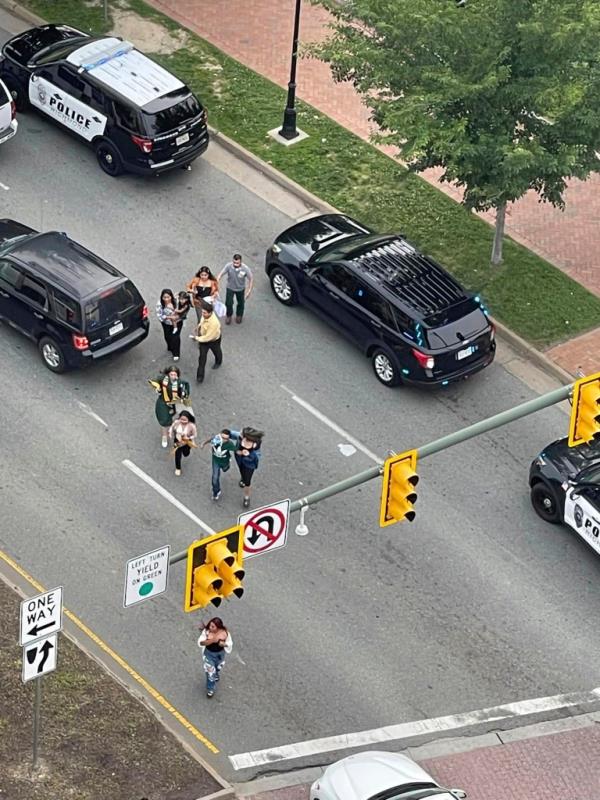 People scatter from a shooting scene as police arrive Tuesday, June 6, 2023.