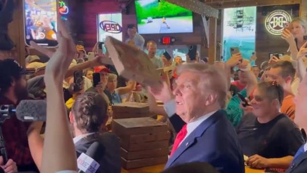 Former President Do<em></em>nald Trump signs an autograph for Ashley Rashid during a stop at the Treehouse Pub & Eatery, Wednesday, Sept. 20, 2023, in Bettendorf, Iowa.