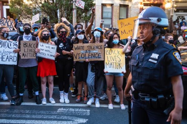 Protesters hold signs on Bedford Avenue in Flatbush, Brooklyn. 