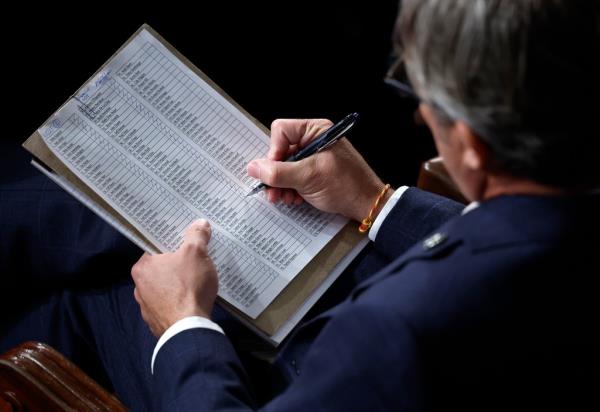 A member tallies votes on the House floor