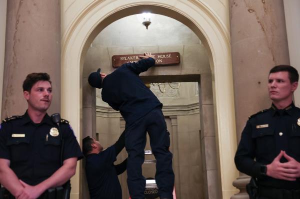 Employees put up a plaque with the new speaker's name on it