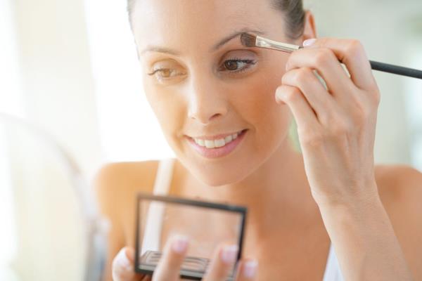 Young woman applying eyeshadow on