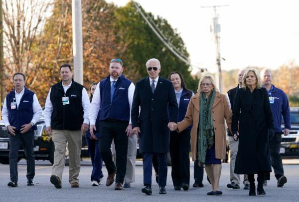 Joe Biden walking and holding hands with others 