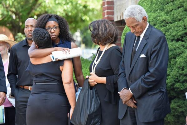 Finch's niece Amira Finch Johnson (pictured, glasses) is comforted by a friend. Elise's mother and father, James and Charlette Finch, are also pictured.  