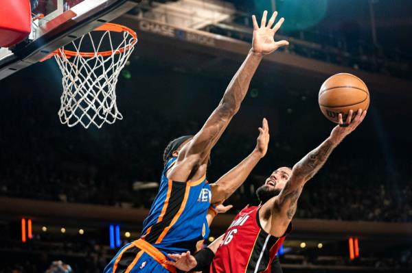 Miami Heat forward Caleb Martin (16) attempts a shot over New York Knicks forward Precious Achiuwa (5) during the first half of an NBA basketball game on Saturday, Jan. 27, 2024, in New York.