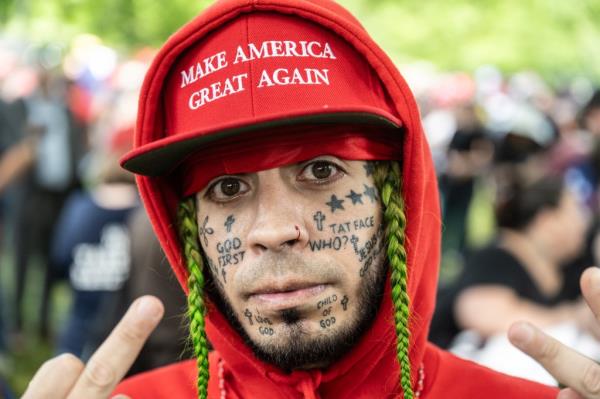 A supporter of former U.S. President Do<em></em>nald Trump poses for a photo as people gather outside of the Crotona Park rally venue.