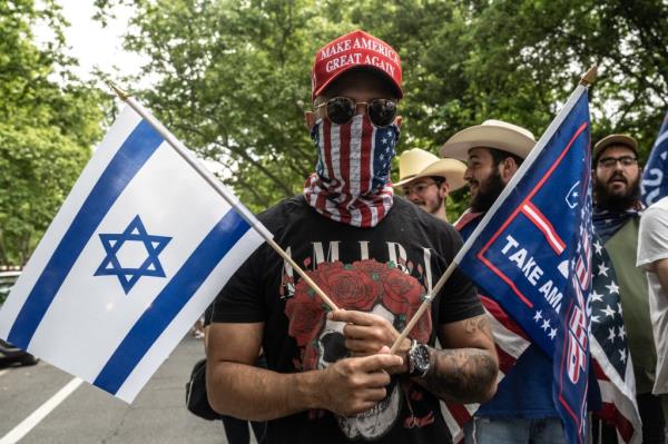  A supporter of former U.S. President Do<em></em>nald Trump holds an Israeli flag as they gather outside of the Crotona Park rally venue in the Bronx borough on May 23, 2024 in New York City