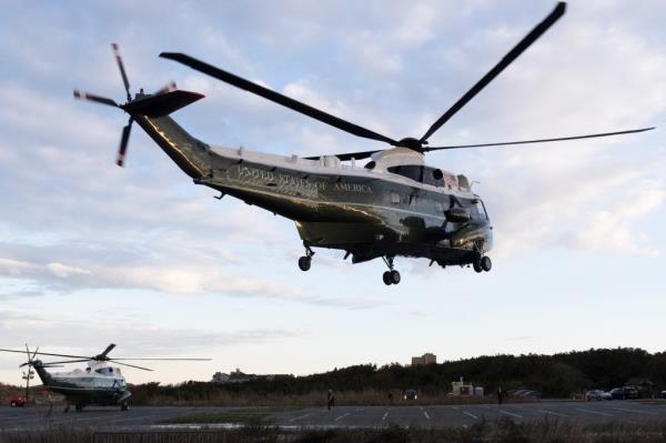 Marine One, carrying President Joe Biden, hovers over a parking area at Gordons Pond in Rehoboth Beach, Del., Friday, April 12, 2024