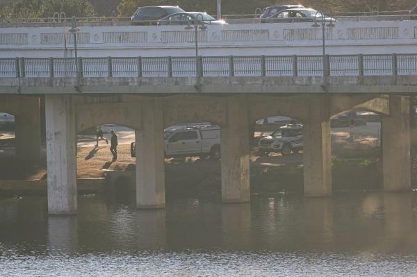 Austin Police Department crime scene investigation vehicles work underneath the First Street bridge on the opposite bank from wher<em></em>e APD respo<em></em>nded to a report of a body in Lady Bird Lake near Downtown Austin on Monday, Feb. 5, 2024.