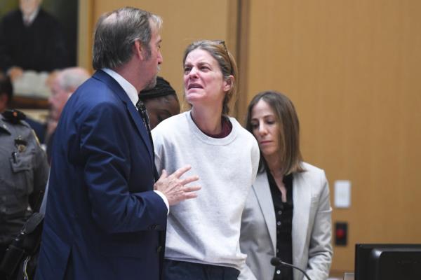 Michelle Troco<em></em>nis speaks with her attorney, Jon Schoenhornher, during her sentence.