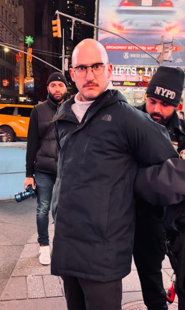 A man being arrested after tearing down Israeli missing persons signs in Times Square.