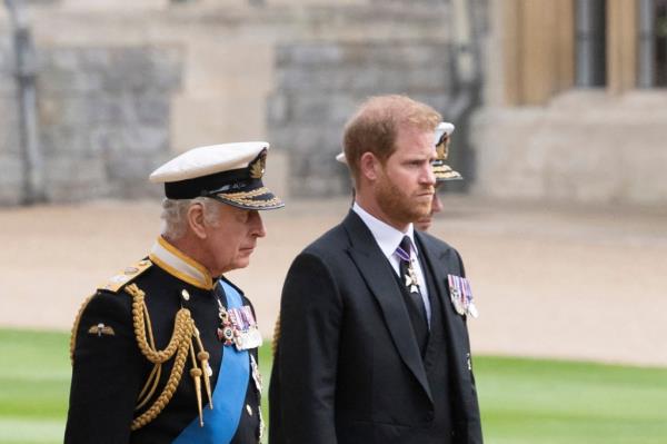 King Charles III and Prince Harry, Duke of Sussex, in military uniforms, walking together at St George's Chapel for Queen Elizabeth II's Committal Service