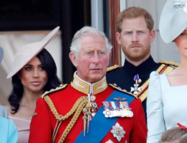 Prince Charles, Prince Harry, and Meghan, Duchess of Sussex standing on the balcony of Buckingham Palace during the Trooping The Colour ceremony.