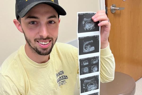 Matthew Gaudreau poses with ultrasound scan photos.