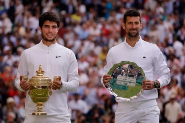 Tennis - Wimbledon - All England Lawn Tennis and Croquet Club, London, Britain - July 16, 2023 Spain's Carlos Alcaraz poses with the trophy after winning his final match alo<em></em>ngside runner up Serbia's Novak Djokovic REUTERS/Andrew Couldridge