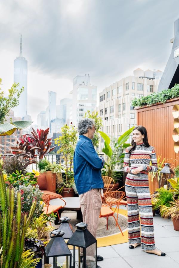 Amar Lalvani and Lydia Moynihan standing on the roof of the Manner hotel, with the Empire State building in the background