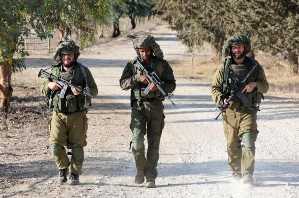 Israeli troops patrol at an undisclosed location along the border with the Gaza Strip on October 19, 2023.