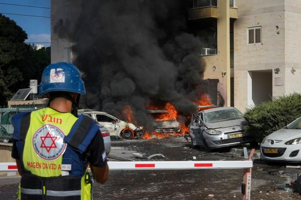 Cars burning after a rocket fired from Gaza landed in Ahskelon, Israel on October 7, 2023.