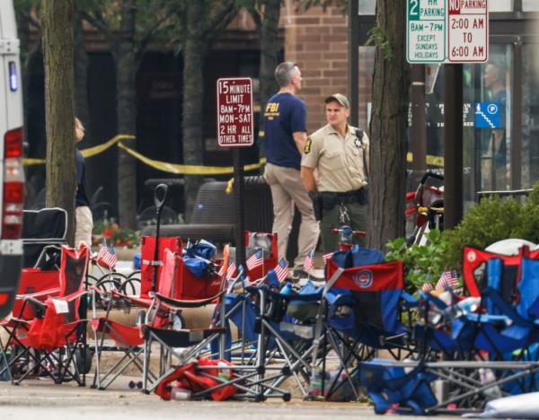 Law enforcement officers  investigation the scene of the mass shooting at a 4th of July celebration in 2022.