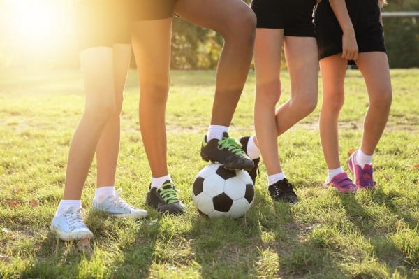 Girls' legs with a soccer ball