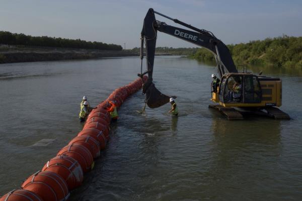 Workers assemble a string of buoys, to deter migrants from crossing the Rio Grande river, at the internatio<em></em>nal border with Mexico in Eagle Pass, Texas, U.S. July 27, 2023.  