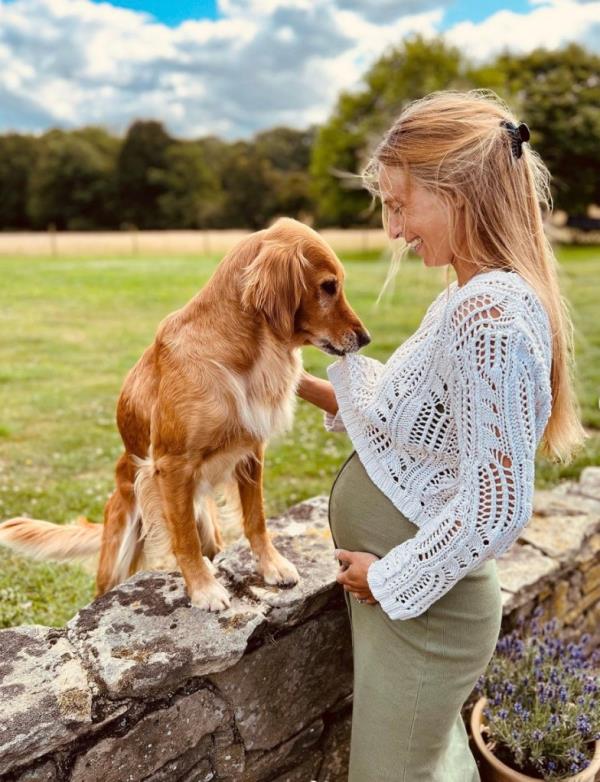 Alizee Thevenet holds her baby bump in a sweet photo with her dog.