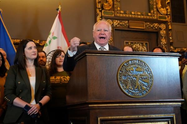 Minnesota Gov. Tim Walz, middle, speaks to the media before signing a bill to legalize recreatio<em></em>nal marijuana for people over the age of 21, May 30, 2023, in St. Paul, Minn.