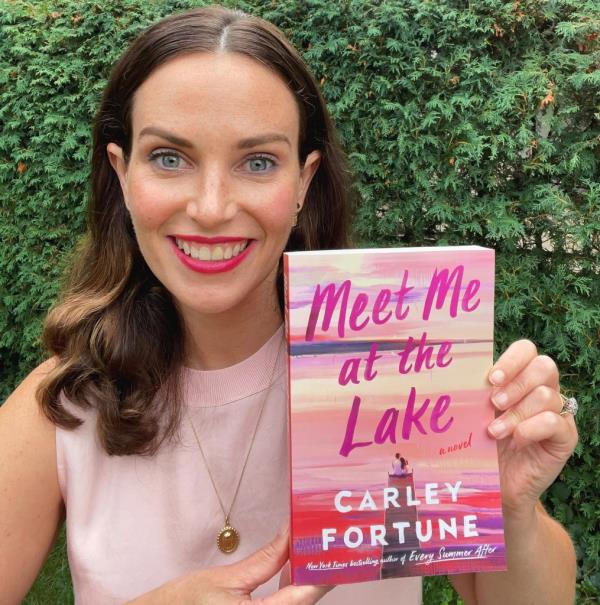 Author Carley Fortune holds her novel, 