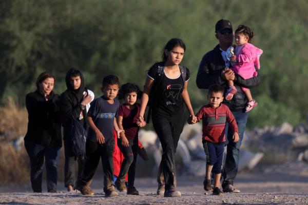 Wet, cold, bedraggled, muddy and many with missing shoes a large group of migrants with many women and children present cross into the United States in Eagle Pass, TX.