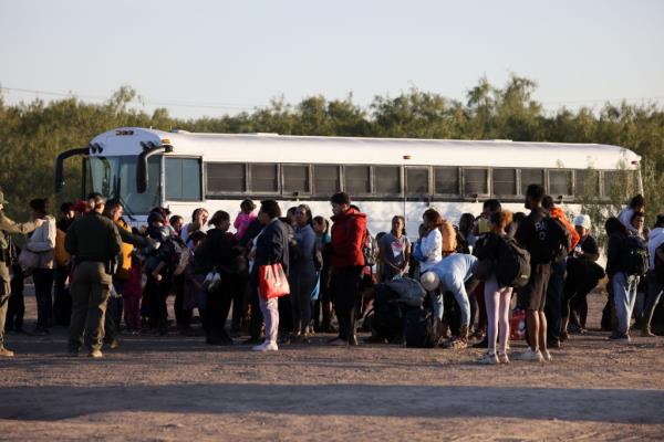 Wet, cold, bedraggled, muddy and many with missing shoes a large group of migrants with many women and children present cross into the United States in Eagle Pass, TX.