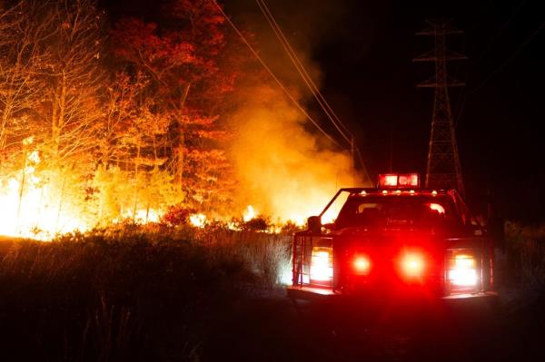 This photo provided by New Jersey Department of Enviro<em></em>nmental Protection firefighters respond to a forest fire on Wednesday, Nov. 6, 2024 in Evesham, N.J.