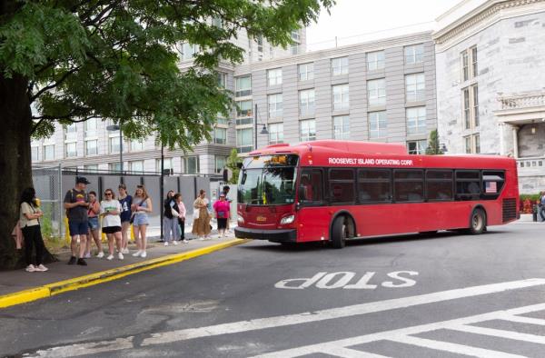 A red bus picks  up riders. 