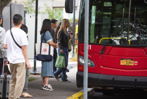 The bus picks up riders. 