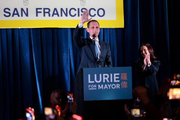 Daniel Lurie, center, waves during his election night watch party at The Chapel in San Francisco, Tuesday.