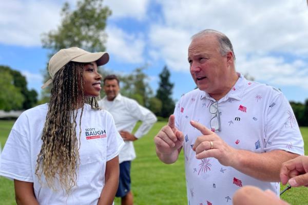 California Co<em></em>ngressional candidate Scott Baugh campaigning in Orange County, standing in a field with a woman on August 17, 2024