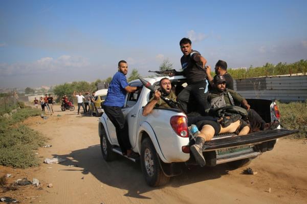 Palestinian militants drive back to the Gaza Strip with the body of Shani Louk, a German-Israeli dual citizen, during their cross-border attack on Israel, Saturday, Oct. 7, 2023. The Israeli military said Friday, May 17, 2024, it found the bodies of three Israeli hostages in Gaza, including Louk. 