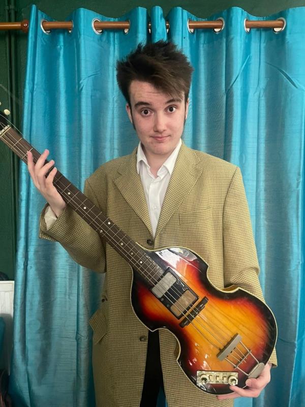 Paul McCartney's legendary stolen bass guitar, found after 50 years, held by Ruaidhri Guest with a cheeky ex<em></em>pression.