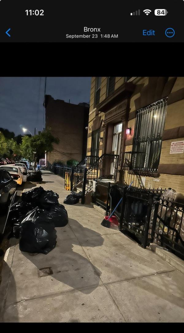 Exterior view of 539 E 147th St with garbage bags on the sidewalk, related to a violation penalty