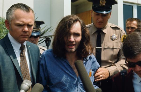 Charles Manson speaks with reporters as he is escorted by a deputy sheriff and his lawyer, Irving Kanarek, from a Santa Mo<em></em>nica courthouse following a hearing in 1970. 