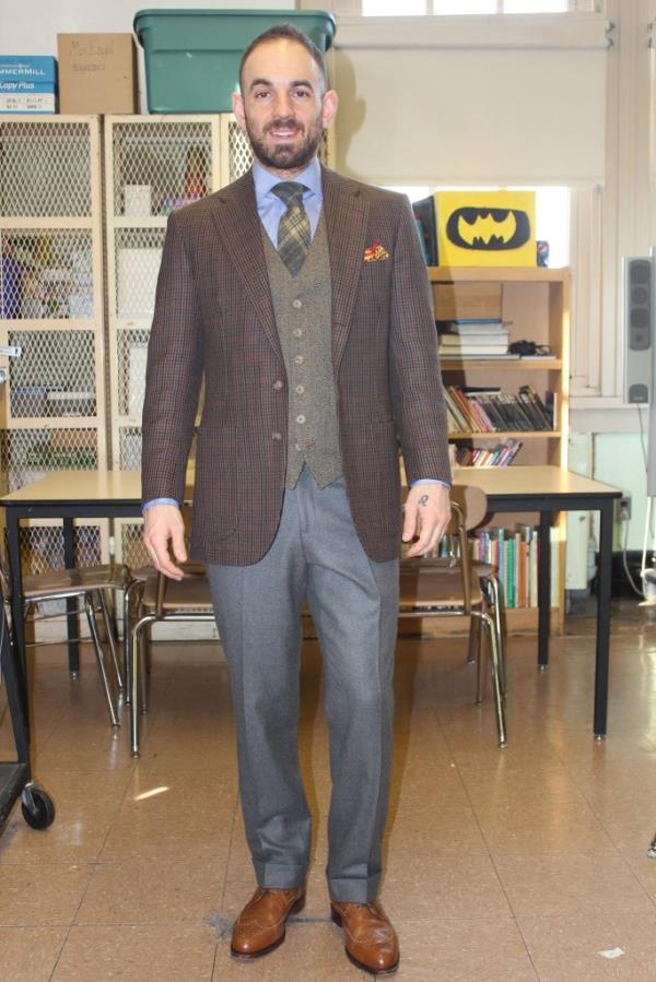 Robert Rossicone, former Bay Ridge social studies teacher, standing in classroom in suit and tie.