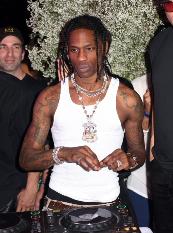 Travis Scott performing at Sinan's Art ba<em></em>sel Party in Miami, Florida, dressed in a white tank top and necklaces