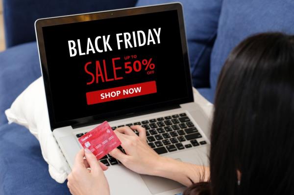 Woman's hands holding credit card and using laptop for o<em></em>nline shopping during Black Friday sale