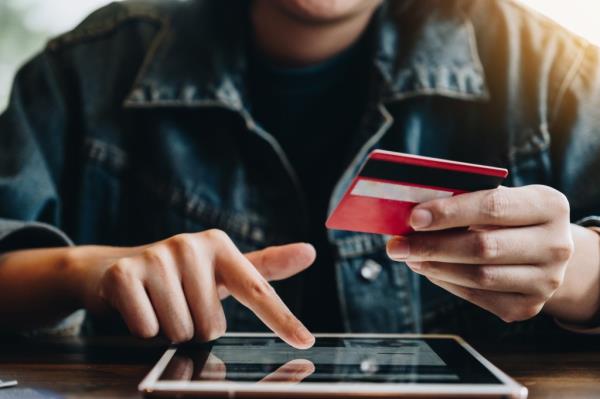 Beautiful woman shopping o<em></em>nline using credit card and laptop on Black Friday