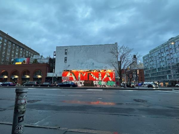 The Bowery wall with various graffiti tags. 