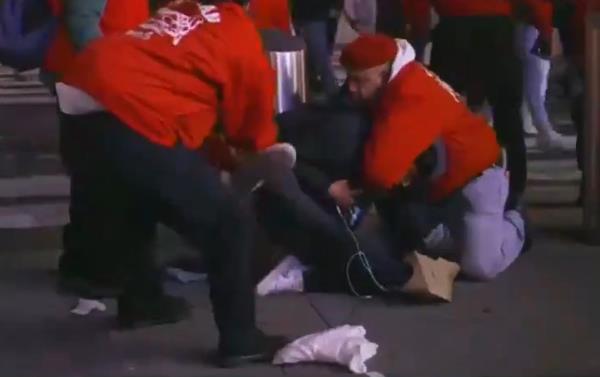 Guardian Angels are seen on live television roughing up a man alleged to be a migrant shoplifter at Times Square